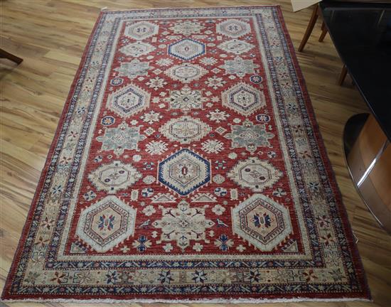 A Kazak style brick red ground rug Approx. 280 x 175cm